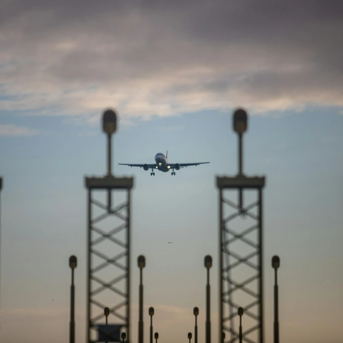 an airplane is flying low over a parking lot